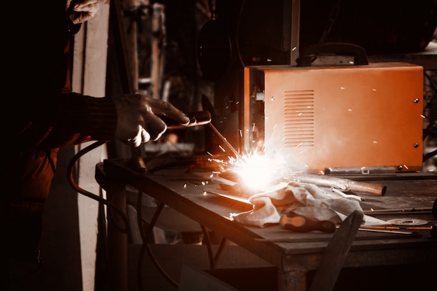 Man welding old shovel, close up.