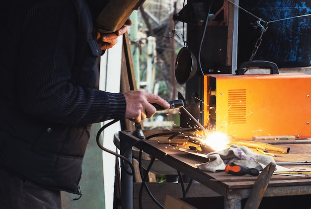 Man welding old shovel, close up.