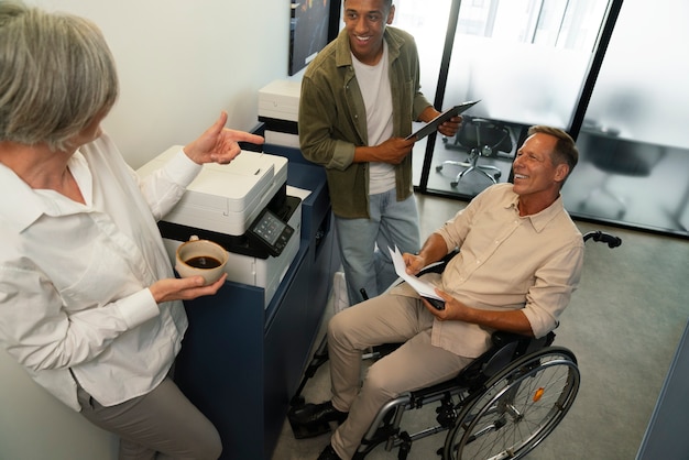 Человек в инвалидной коляске работает в офисе