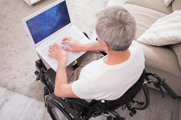 Free photo man in wheelchair typing on laptop