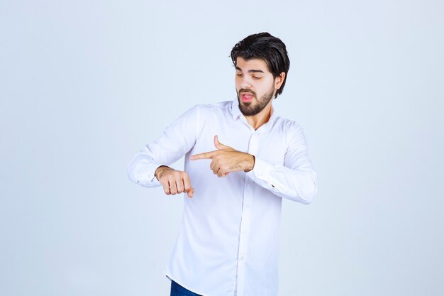 Man in a white shirt checking his time