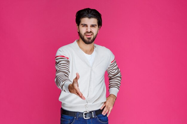 Man in white shirt greeting and inviting someone. 