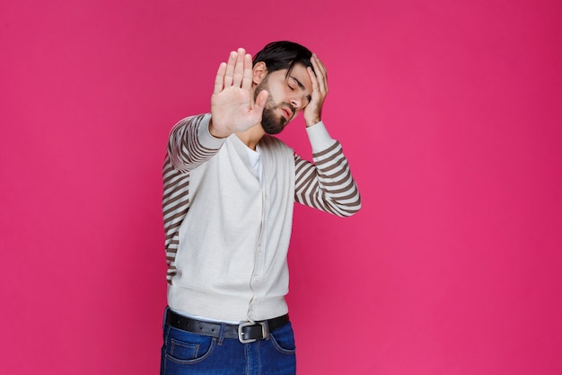 Man in white shirt has headache and holding his head. 