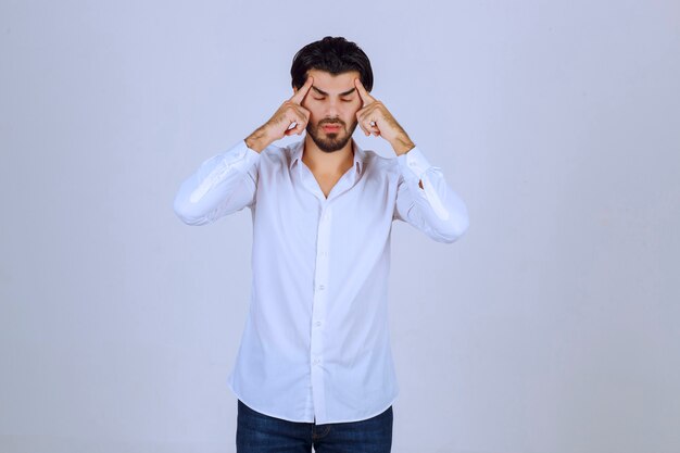 Man in white shirt looking and thinking.