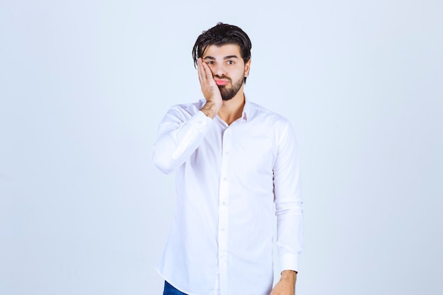 Man in a white shirt looks confused and lost