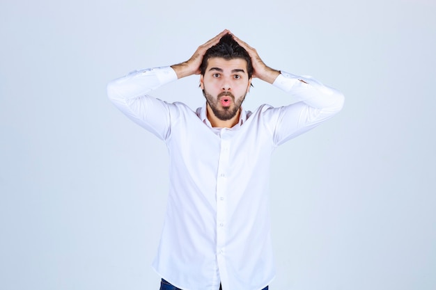 Man in a white shirt looks confused and lost