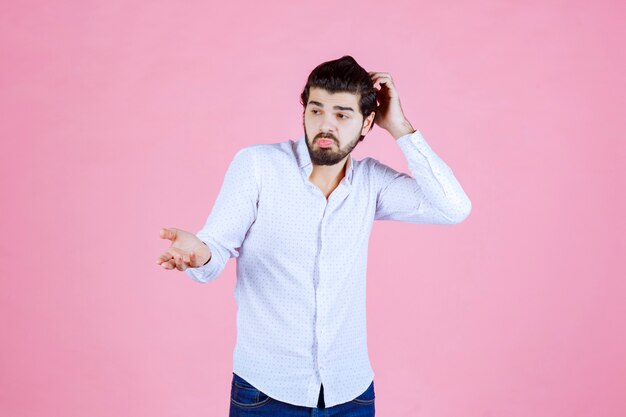 Man in a white shirt looks confused and lost.