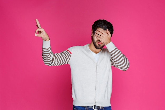 Free photo man in a white shirt making finger circle sign.