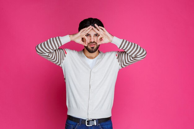 Free photo man in a white shirt making finger circle sign.