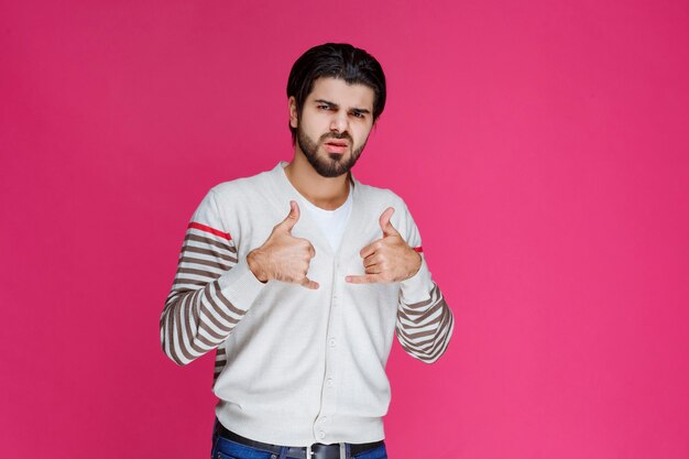 Man in a white shirt making thumb up sign. 