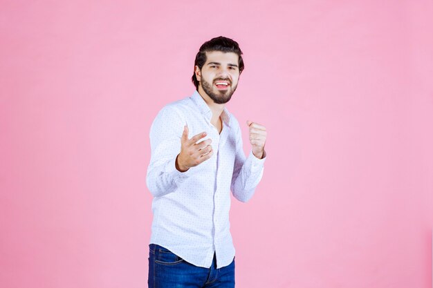 Man in a white shirt noticing and pointing at the person ahead.