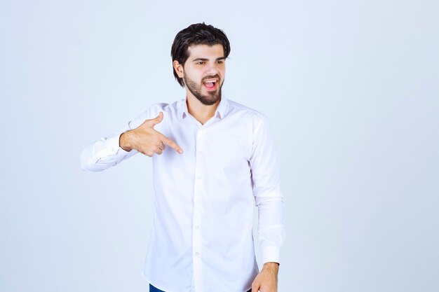 Man in white shirt pointing at himself.