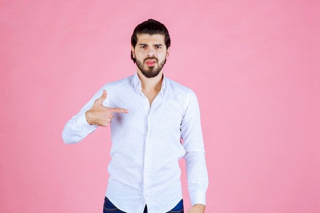 Man in a white shirt pointing at himself.