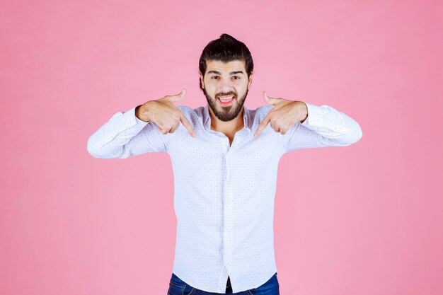 Man in a white shirt pointing at himself.