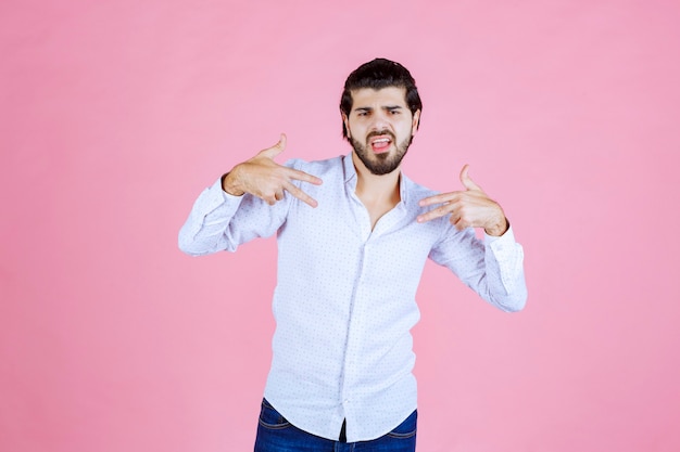 Free photo man in a white shirt pointing at himself.