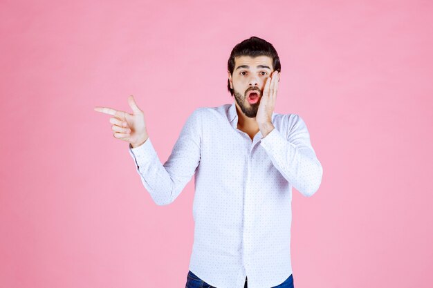 Man in a white shirt pointing at the left side.