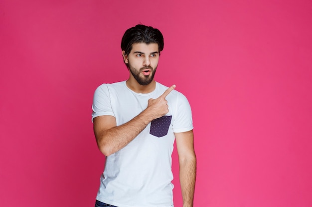 Man in white shirt pointing and presenting something in the right side.