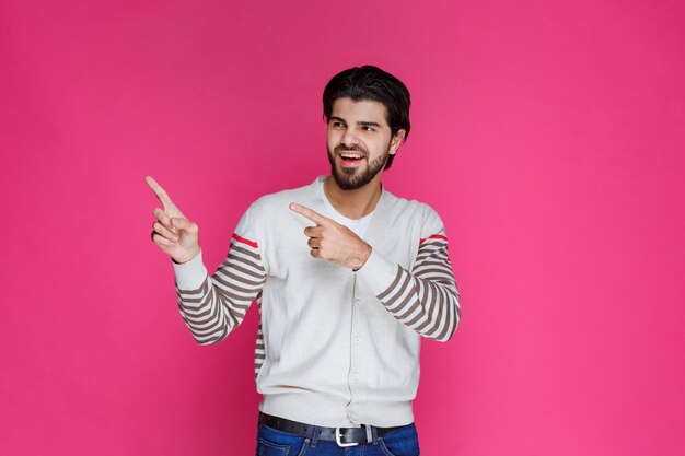 Man in white shirt pointing and presenting someting on the left side. 