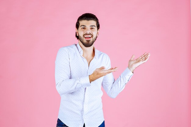 Man in a white shirt pointing to the right side.