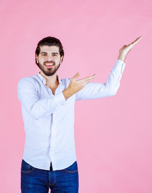 右側を指している白いシャツを着た男。