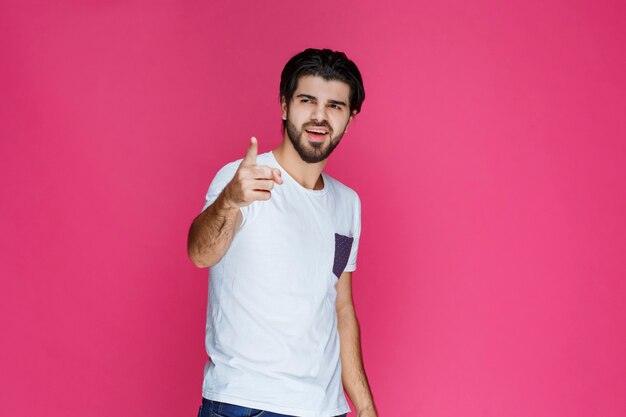 Man in white shirt pointing at something ahead. 