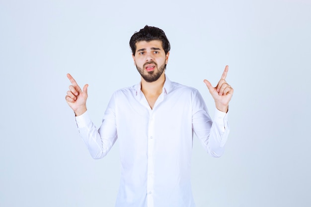 Man in a white shirt pointing above