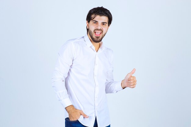 Man in a white shirt showing enjoyment hand sign