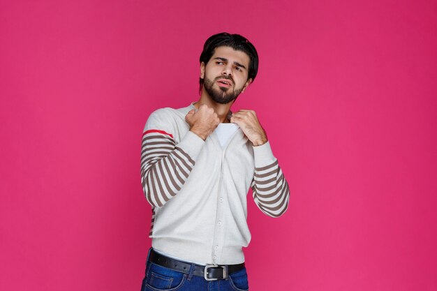 Man in white shirt showing his fist and biceps muscles. 