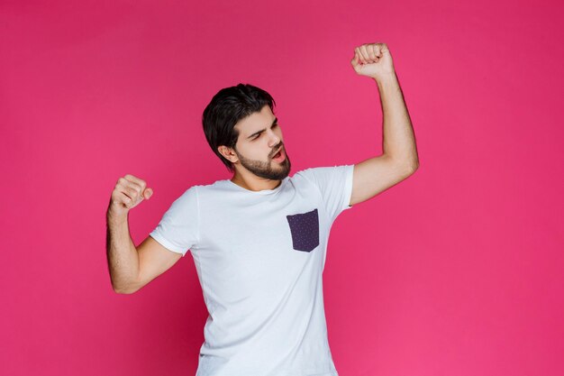 Man in white shirt showing his fists and power. 