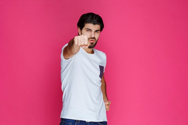 Man in white shirt showing his fists and power. 