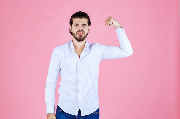 Man in a white shirt showing his powerful fists.