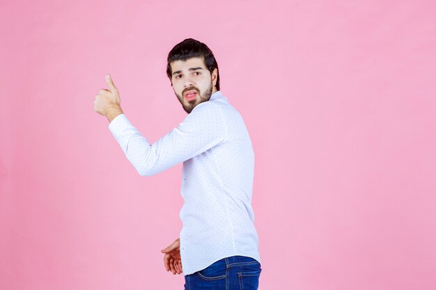 Man in a white shirt showing positive hand sign.