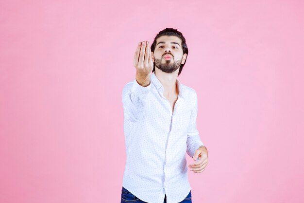 Man in a white shirt showing positive hand sign.