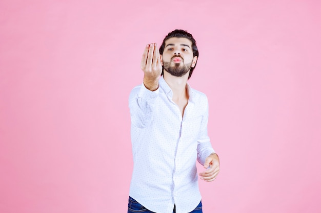 Man in a white shirt showing positive hand sign.