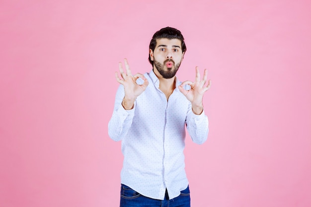 Man in a white shirt showing positive hand sign