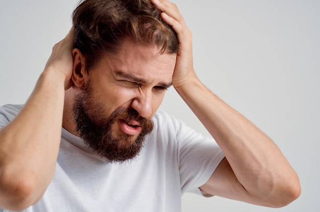 Man in a white tshirt headache migraine problems studio treatment