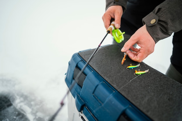 Uomo in abiti invernali che pesca da solo all'esterno