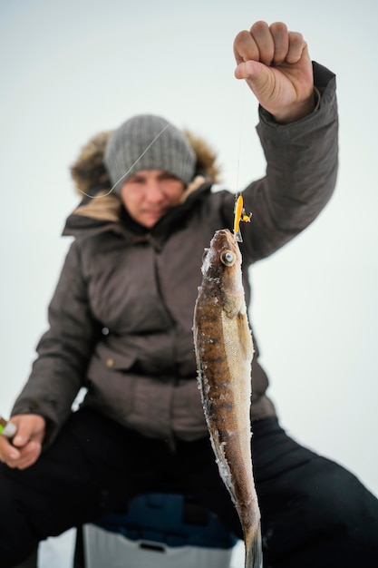 Man in winter clothes fishing alone outside