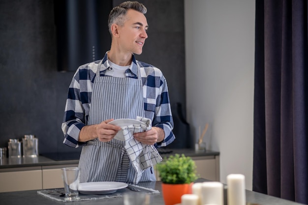 Free photo man wiping plate with napkin looking to side