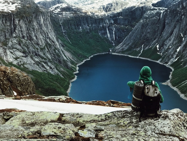 Бесплатное фото Человек с рюкзаком восхищается великолепным горным пейзажем