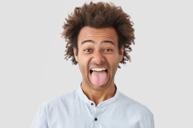 アフロの髪型の男は、嫌なことに気づき、しかめっ面をし、頑固な性格を示すように舌を見せます
