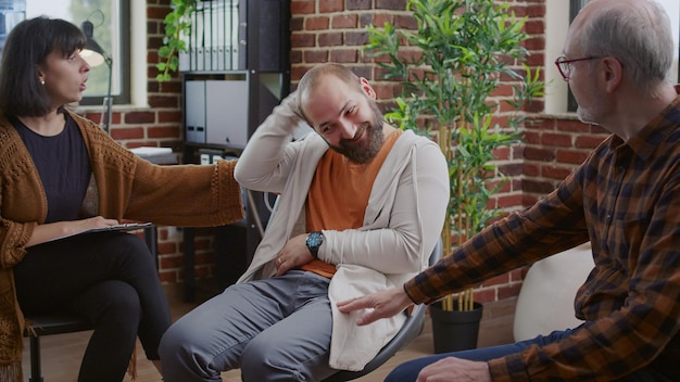 Free photo man with anger management issues attending aa group therapy meeting to receive support and guidance. angry person with mental health problems talking to people at rehabilitation program