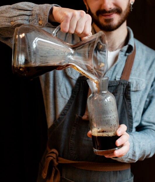 Man with apron pouring coffee in jar