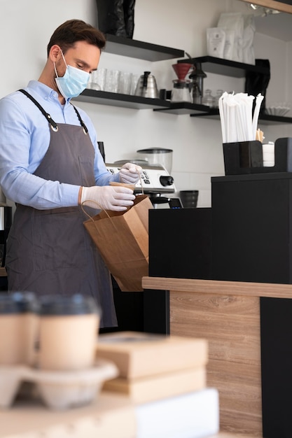 Free photo man with apron preparing food for takeaway