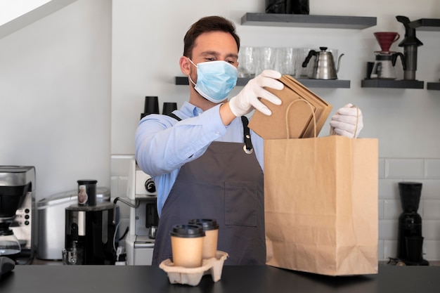 Uomo con grembiule che prepara cibo da asporto