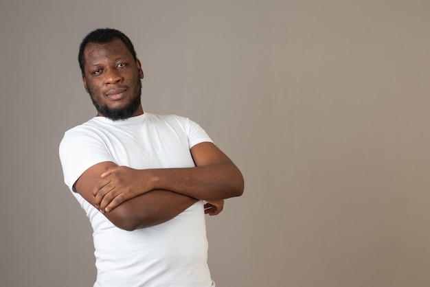 man with arms crossed ,standing in front of the grey wall