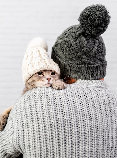 小さな子猫を保持している背中を持つ男