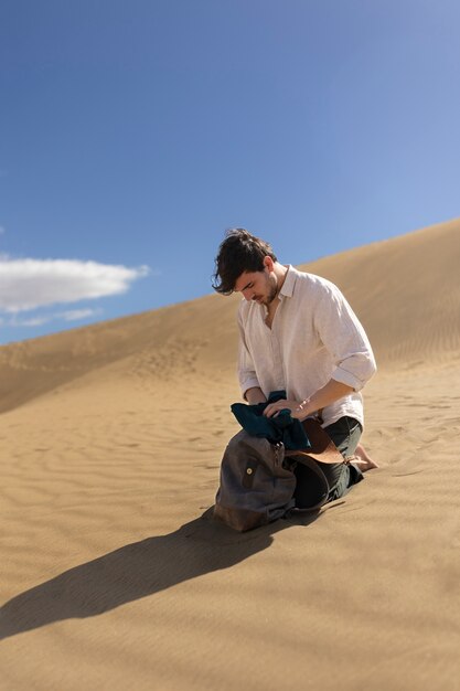 man with backpack in desert full shot