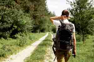 Free photo man with backpack exploring nature