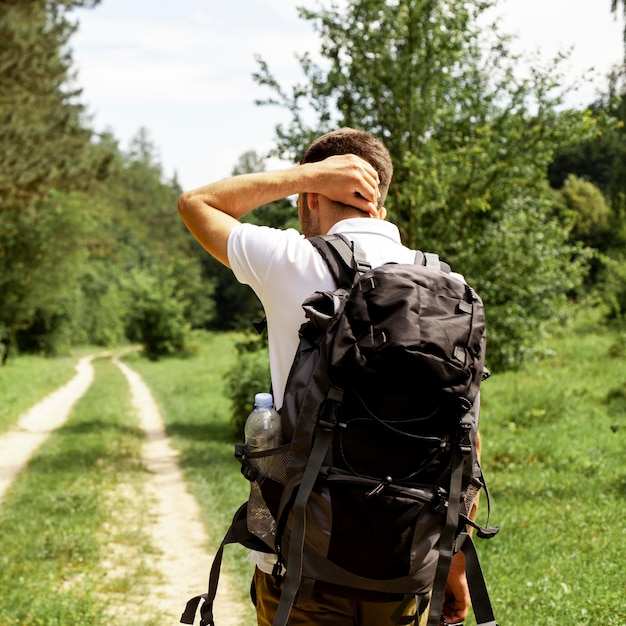 Man with backpack on forest road